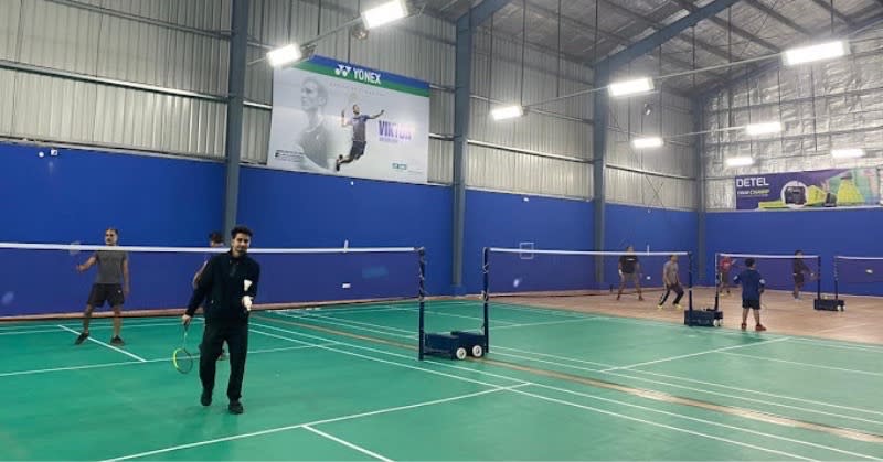 Two players playing badminton indoors in Delhi NCR